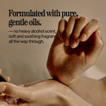 Close-up of a person's hands holding and applying a cosmetic product, with text on the left reading 'Formulated with pure, gentle oils. — no heavy alcohol scent, soft and soothing fragrance, all the way through.