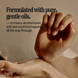 Close-up of a person's hands holding and applying a cosmetic product, with text on the left reading 'Formulated with pure, gentle oils. — no heavy alcohol scent, soft and soothing fragrance, all the way through.