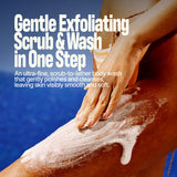 A person applies SANDY SCRUB WASH, a foamy coconut exfoliating body wash, to their leg with the ocean in the background. Overlay text highlights this gentle body wash that polishes and cleanses skin in one step for irresistibly smooth results.
