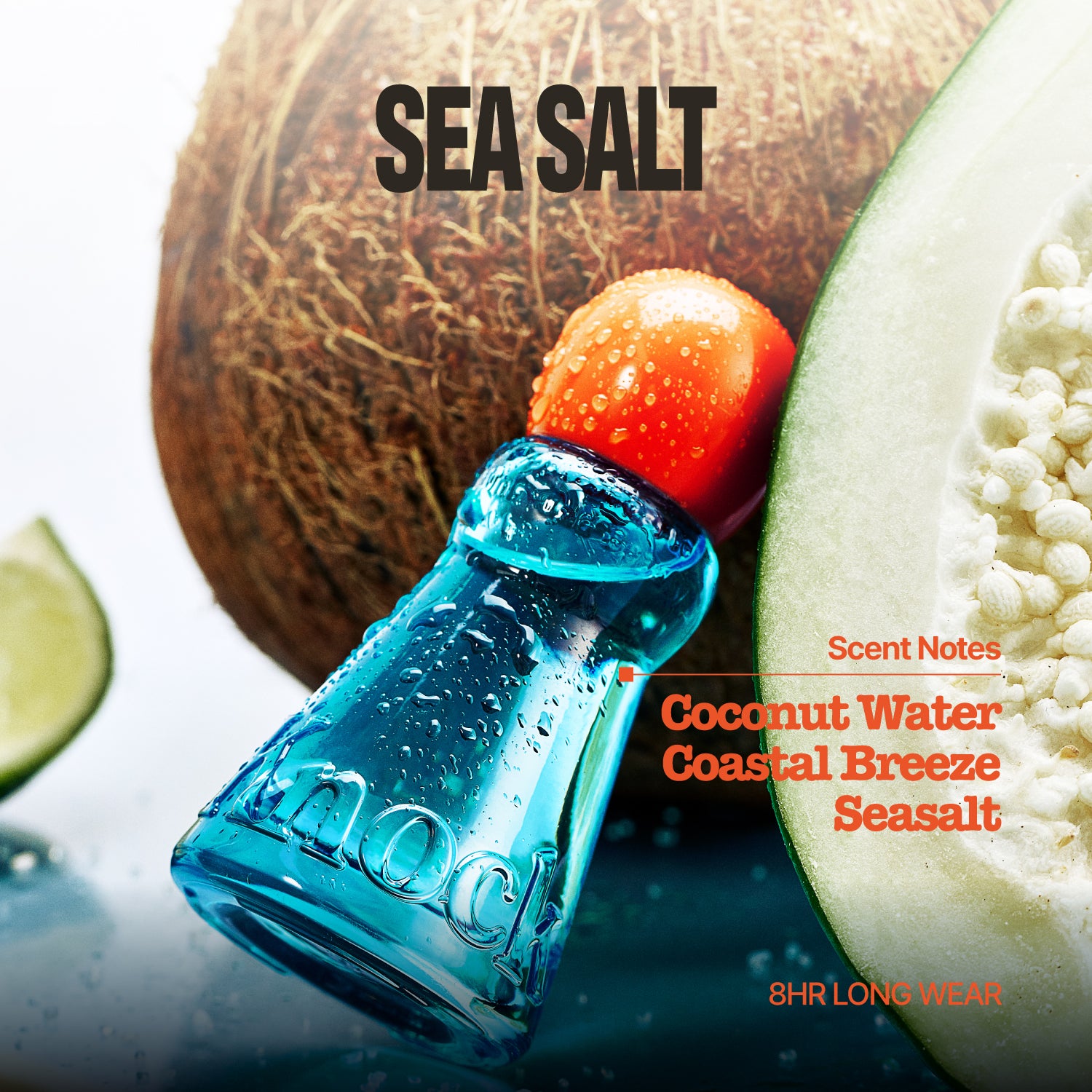 A small blue glass salt shaker bottle with a bright orange-red cap sits in front of a halved coconut and lime slices. Text on the image reads 'SEA SALT' and 'Scent Notes Coconut Water Coastal Breeze Seasalt 8HR LONG WEAR'.