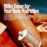 While sitting on a red lounge chair, a person applies MELT IN BODY TONER from its sleek silver bottle to their leg. The description emphasizes the toner’s lightweight, hydrating, and residue-free formula inspired by Korean skincare, noting how it absorbs instantly to provide lasting comfort.