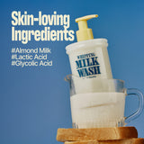 A bottle of WHIPPING MILK WASH SEOUL VANILLA with a pump sits in a glass measuring cup filled with milk, balanced on two bread slices. This hydrating body wash is enriched with skin-loving ingredients like #AlmondMilk, #LacticAcid, and #GlycolicAcid to leave your skin healthy and nourished.
