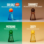 Four small perfume atomizer bottles arranged in a 2x2 grid with scent names and hashtag text: SEA SALT on blue, CARAMELT on tan, PISTACHIO on green, and ZESTY on peach. The bottles are shaped like chess pawns, with translucent colored bodies and round tops in orange, brown, green, and yellow.